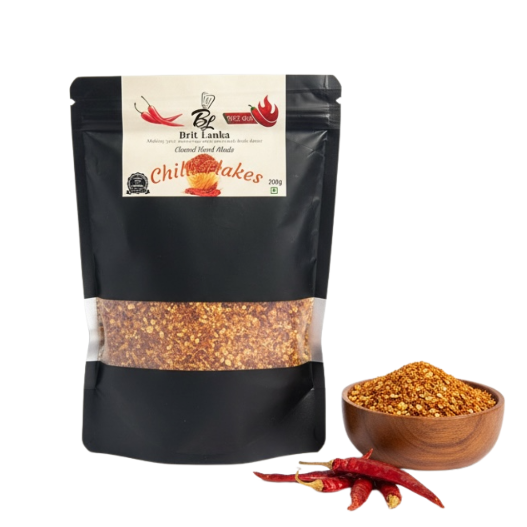 Black packaging of Brit Lanka Chilli Flakes with a bowl of chilies and red chillies on a white background