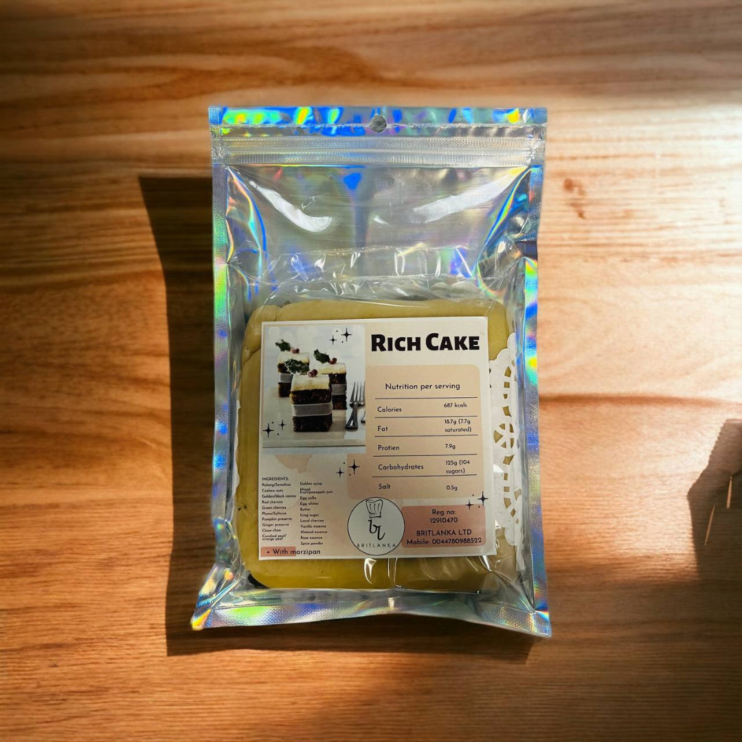 A packaged Rich Fruit Wedding Cake with Almond Icing, 500g, displayed on a wooden surface.