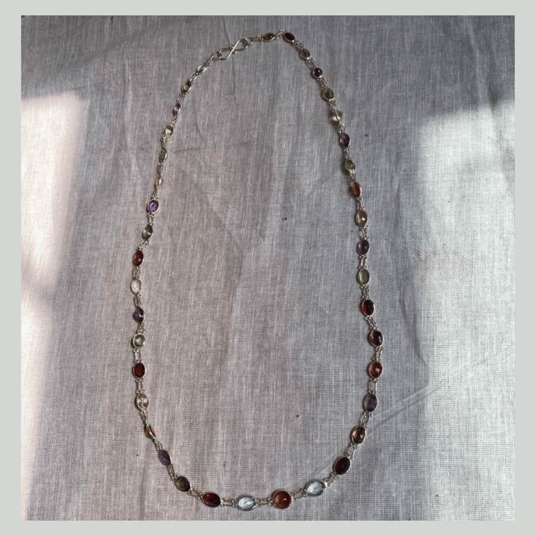 Necklace with multicolored beads on a textured fabric background