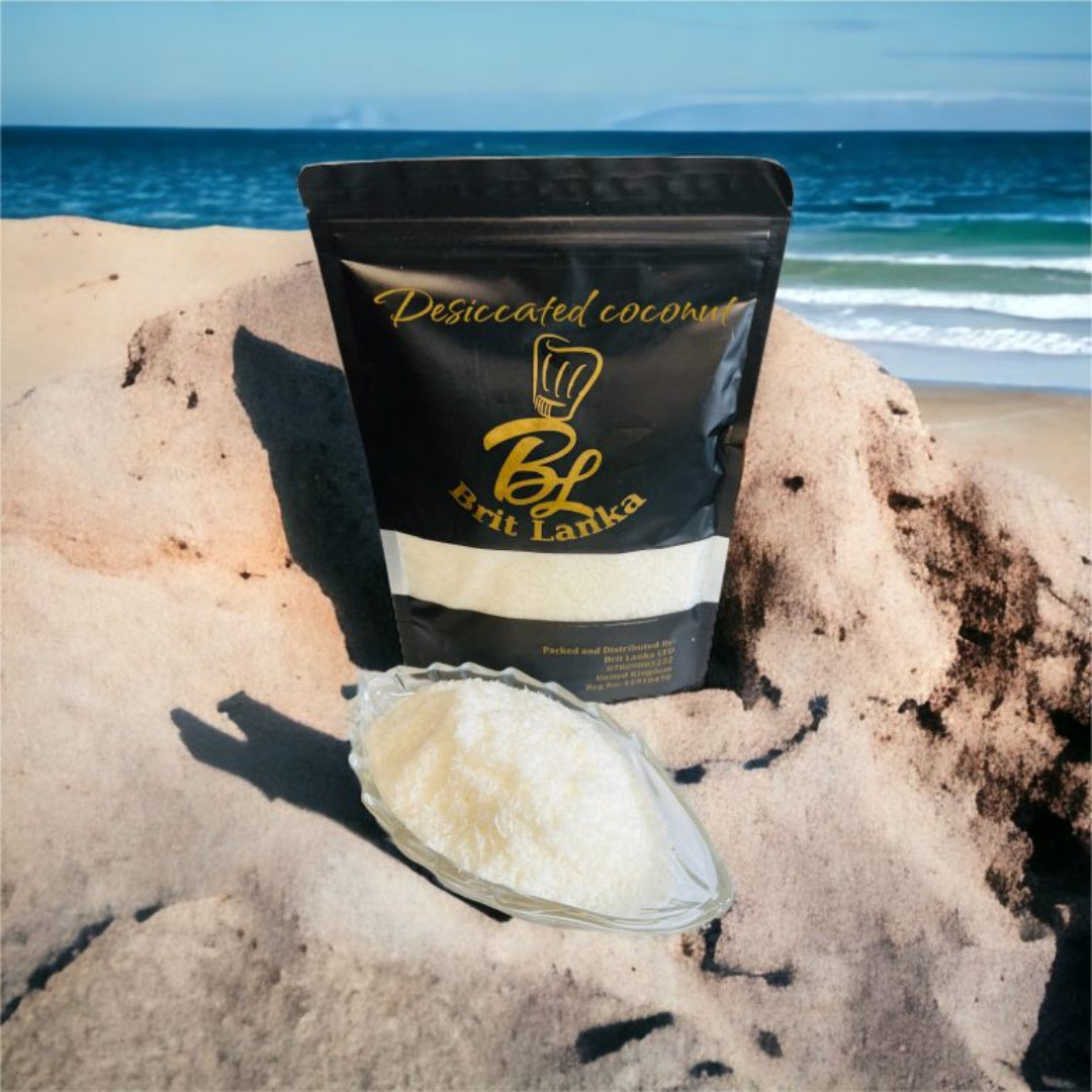 A resealable bag of Ceylon desiccated coconut placed on a rock with the ocean in the background, alongside a small bowl filled with desiccated coconut.