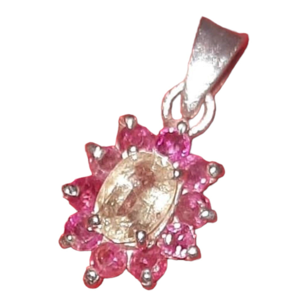 A silver pendant featuring a central yellow sapphire with pink sapphire accents around it, set against a white background.